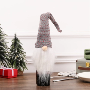 Detail of knitted Christmas gnome wine bottle topper with grey hat and white beard