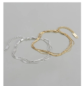 Makroaufnahme des S925-Stempels auf mehrlagigen Gold- und Silberkettenarmbändern für Damen