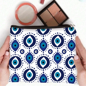Evil Eye printed makeup bag with zipper closure shown being held in a lifestyle setting