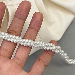 Detailed macro shot of multi-layer white faux pearl strand with elegant glossy finish