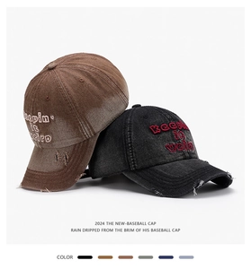 Detail of distressed denim baseball cap with vintage embroidery and frayed edge textures