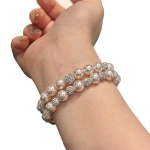 Elegant double-layer pearl bracelet with rhinestone pavé balls on a female wrist