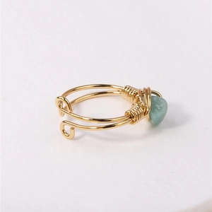 Handmade gold wire-wrapped ring featuring an irregular light green natural crystal stone