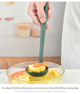 Detailed view of a green heat-resistant silicone soup ladle serving fresh vegetables