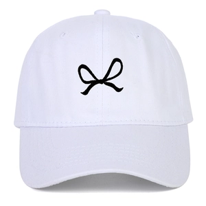 Close-up of black ribbon bow embroidery on a premium white cotton baseball cap fabric