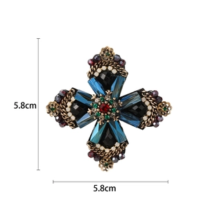 Barokke kruisbroche met blauwe kristallen en rood-groene kralen op gouden basis