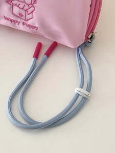 Close-up of Happy Puppy embroidery on pink cosmetic bag with adjustable blue lanyard cord