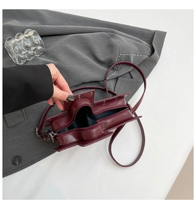Detail view of burgundy PU leather crossbody bag interior with zipper and metal chain