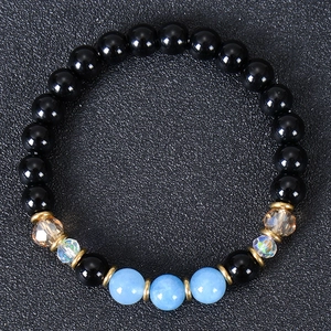 Macro view of multi-color natural stone beads bracelet with gold gear spacers on dark background