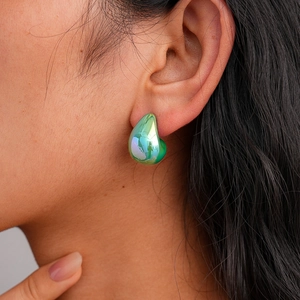 Close-up of teardrop earrings with green and purple gradient metallic finish on model