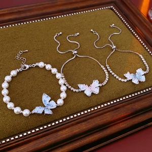 Détails des breloques papillon et perles sur des bracelets élégants réglables