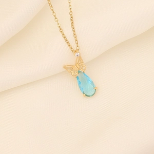 Macro shot of blue teardrop gemstone pendant with gold butterfly and small diamond detail