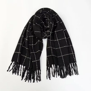 Close-up of black and white windowpane scarf showing soft fabric and long fringe details