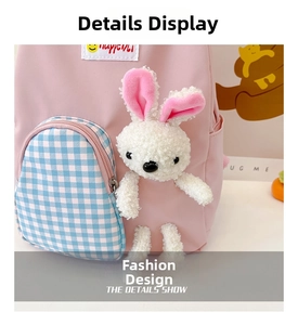 Close-up of pink canvas backpack featuring a plush bunny and checkered zipper pocket detail