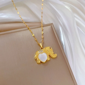 Elegant gold elephant necklace with heart-shaped opal stone inlay on soft silk background