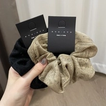 Close-up of elegant textured satin bow hair clips in black and champagne beige