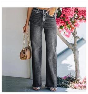 Detailed view of dark grey high-waisted wide leg jeans with raw hem and washed texture