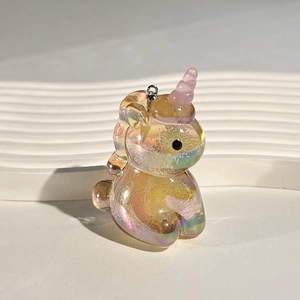 Macro detail of translucent iridescent acrylic unicorn pendant with shiny silver metal hook