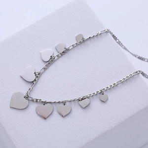 Minimalist silver chain necklace with multiple heart-shaped sequins on geometric stand