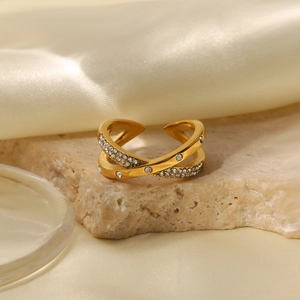 Detailansicht des 18K vergoldeten Crossover-Rings mit Kristallen auf Steinplatte