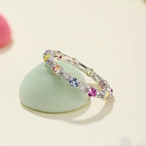Bague ouverte en argent S925 avec zircons colorés posée sur une pierre décorative