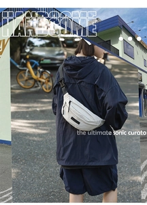 Detail of a white nylon crescent crossbody bag featuring a black zipper and adjustable strap