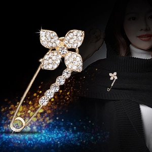 Elegant gold swan brooch pin with rhinestones shown on black background and worn on a collar