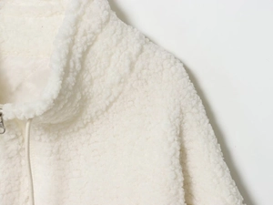 Detail of high collar and plush texture on white fleece jacket with metal zipper