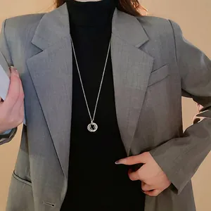Minimalist interlocking triple ring pendant necklace in silver on a chic black turtleneck