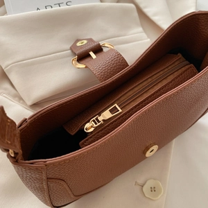 Detail of lychee pattern leather underarm bag with gold zipper and metal buckle