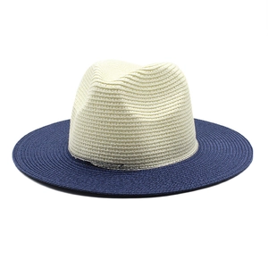 Detail of two-tone woven straw panama hat with cream crown and navy blue wide brim