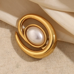 Chic 18K gold plated conch spiral brooch with a large oval pearl on silk background