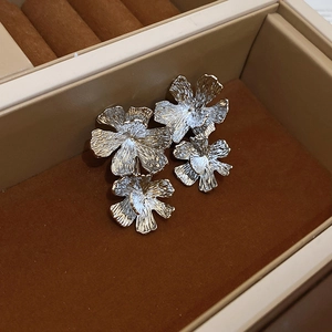 Detail of silver floral earrings with double petals in a brown velvet jewelry box
