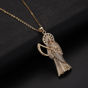 Vue détaillée du pendentif Santa Muerte doré avec faux diamants et faux cristal brillant