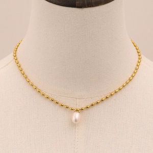 Gros plan détaillé du collier en perles d'or 18k avec un seul pendentif perle blanche