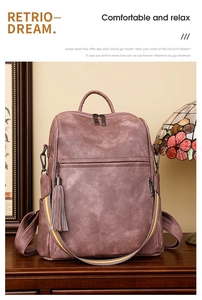 Detail of vintage pink leather backpack with colorful woven strap and metallic zippers