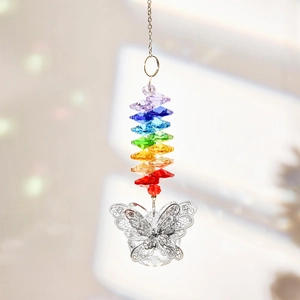 Close-up of a multifaceted crystal suncatcher with an intricate silver butterfly pendant