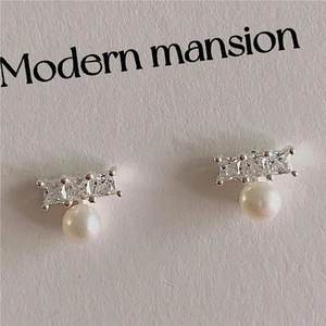 Macro shot of S925 silver earrings with square-cut zircons and round white pearls