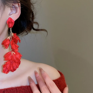 Detail of red fabric flower drop earrings showing layered silk petals and golden chains