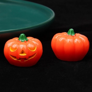 Detailed macro shot of two miniature Halloween pumpkins with glowing resin finish