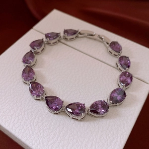 Detailed macro view of purple teardrop zircon stones on a luxury silver bracelet