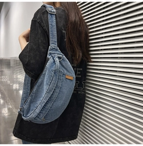 Detail view of the washed blue denim crossbody bag featuring an adjustable wide strap