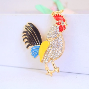 Detailed view of rooster keychain with colorful enamel coating and sparkling rhinestones