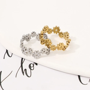 Detailed close-up of hollow daisy flower rings in gold and silver stainless steel