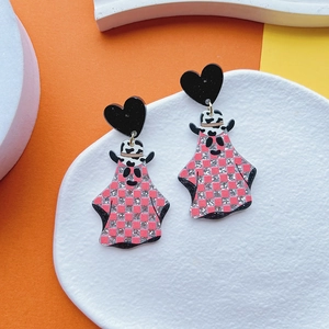 Detail of Halloween ghost earrings featuring pink glitter checks and a cow print cowboy hat