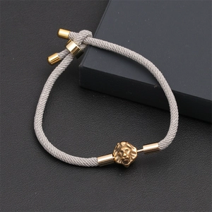 Detailed view of the grey braided cord bracelet with a golden lion head and adjustable clasp