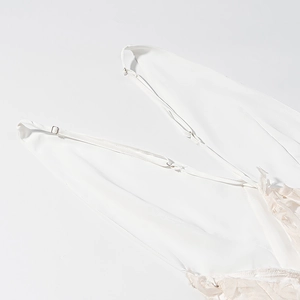 Detail view of adjustable thin straps and delicate white lace stitching on the dress