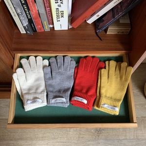 Close-up of colorful knitted touch screen gloves in white, grey, red and mustard yellow
