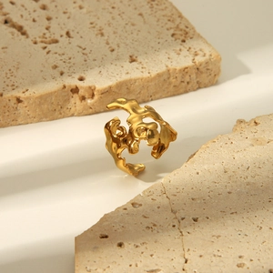 Nahaufnahme eines goldenen Rings mit Lavatextur zwischen zwei natürlichen Dekosteinen
