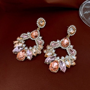 Detailed view of vintage teardrop earrings with champagne and pink crystals on velvet